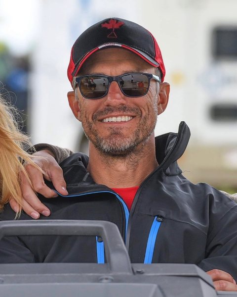 Chuck Kraus in a Team Canada cap, smiling from the judges' stand
