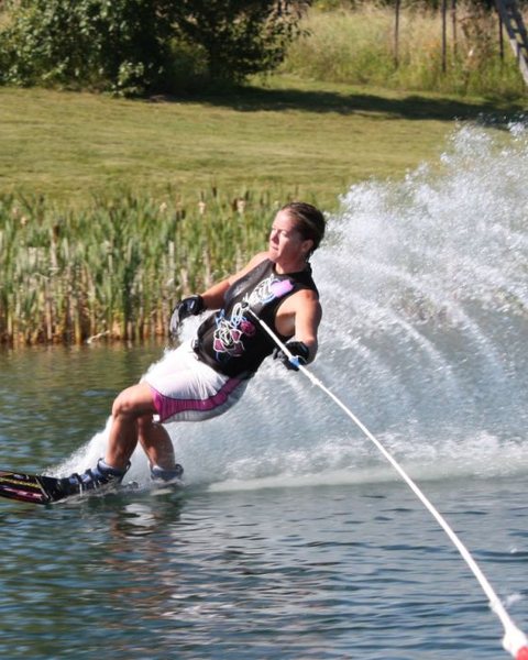 Kristy Kraus leaning into a slalom turn, shot from the boat