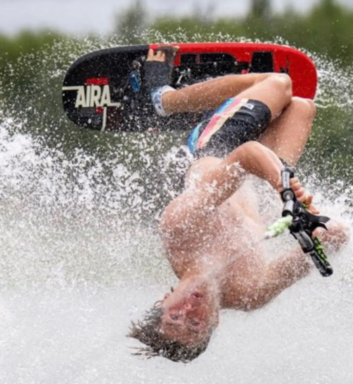 A man falling off his board while riding water skis.