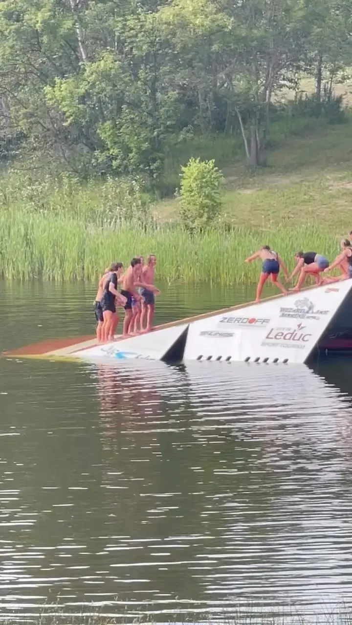 A group of people standing on the side of a boat.