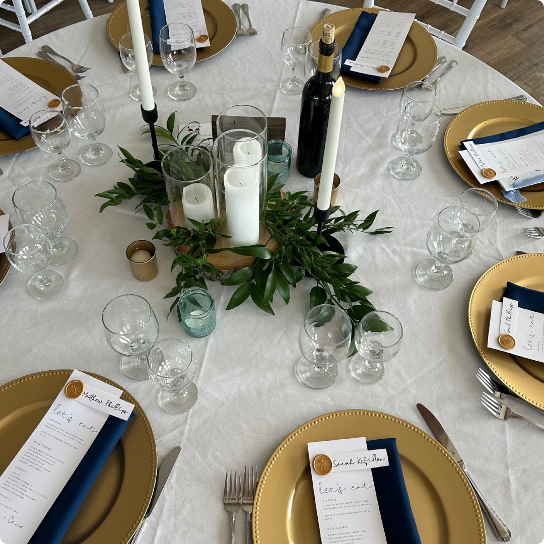 A table set with plates, silverware and candles.