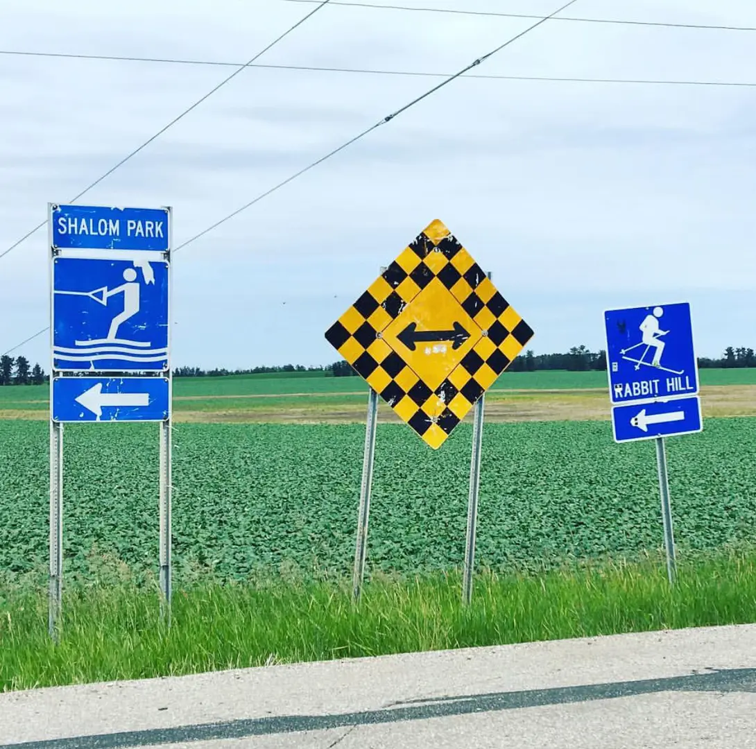 A bunch of signs that are on the side of a road