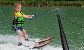 A young boy is water skiing on the lake.