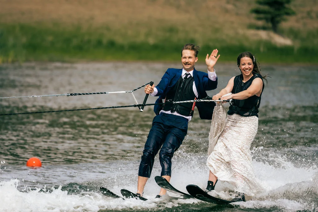 A man and woman riding water skis on top of a lake.