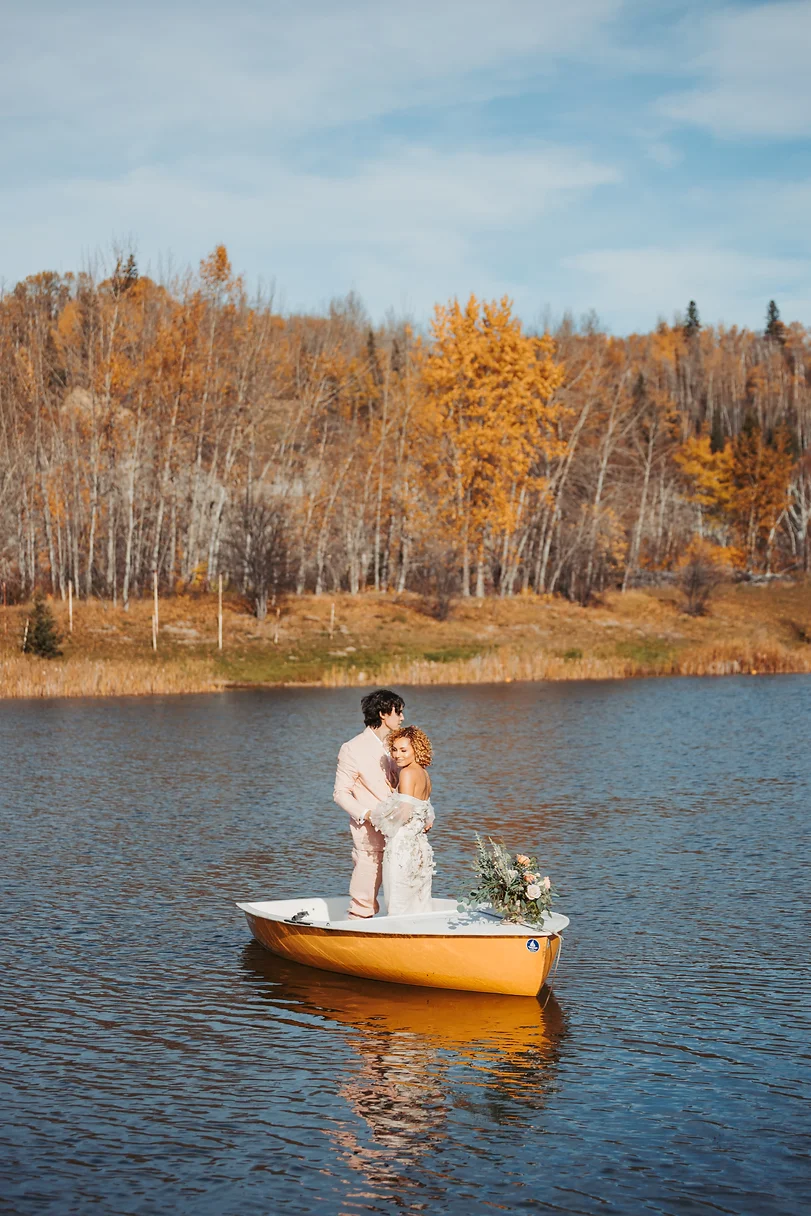 A couple is standing on the back of a boat