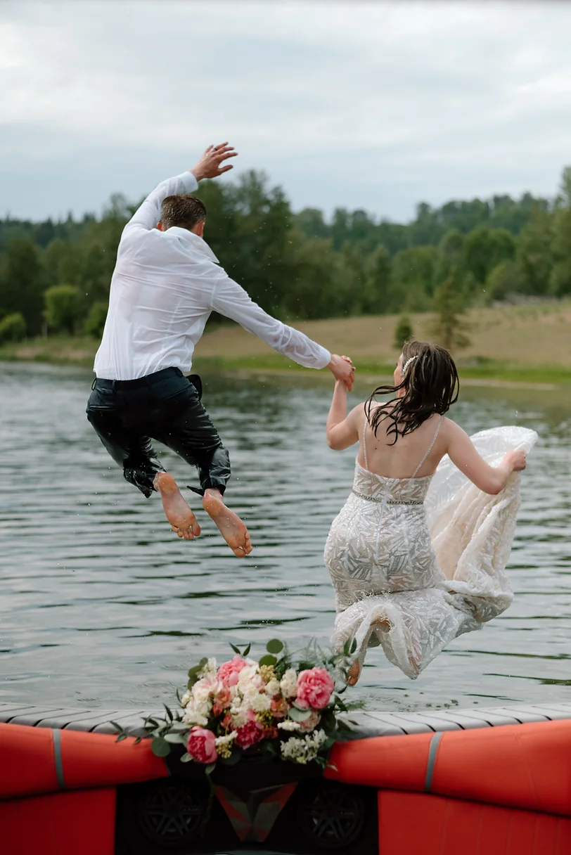 A man and woman jumping into the water.