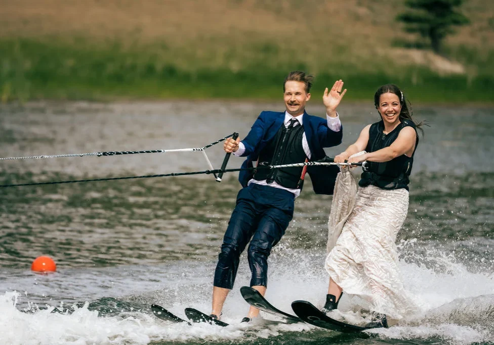 A man and woman riding water skis on top of a lake.